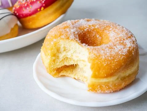 Donuts with sugar sprinkles with bite mark on a white background. Foto stock