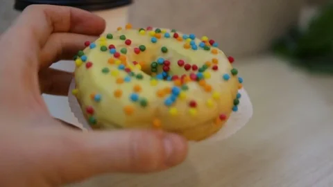 Donuts is on the table, on the background of the coffee Cup. Female hand takes t Stock Footage 85037308