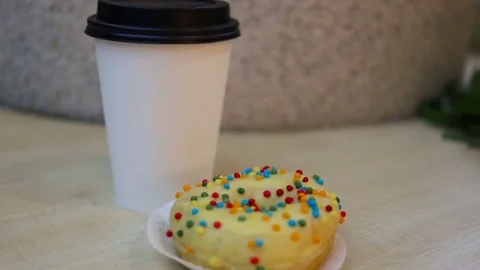 Donuts is on the table, on the background of the coffee Cup. Indoors, natural li Stock Footage 85037322