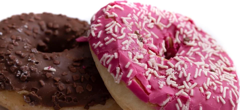 Donuts on a white background, two multi-colored donuts. Stock Photos