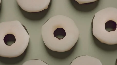 Donuts with white frosting on a white surface Stock Footage 255720154