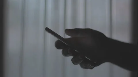 Doom scrolling. Finger of bored man scrolls page app on mobile phone. Side view Stock Footage 234145710