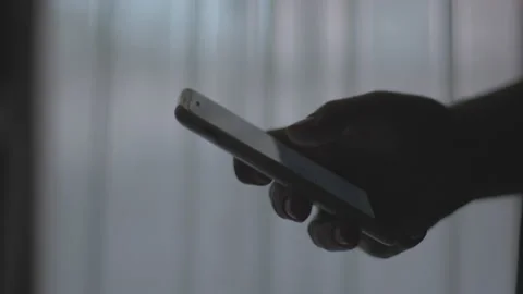 Doom scrolling. Man's hand scrolls page app on mobile phone, side view Stock Footage 234188244