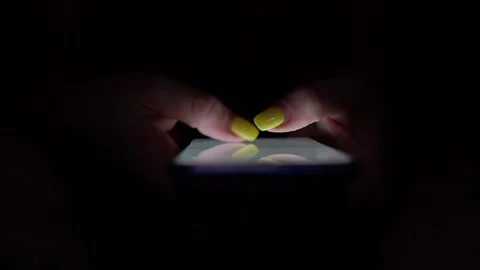 Doomscrolling. Young female checking on her phone during the night. 스톡 동영상 163271732