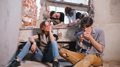 Doomsday, apocalypse. Two survived people sitting on the floor and smoking Stock Footage 110736216