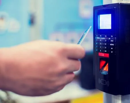 Door access control. Selective focus to card reader machine with blurry staff 스톡 사진