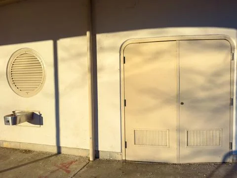Door and round window on a simple wall in the afternoon light in a quiet ar.. Stock Photos