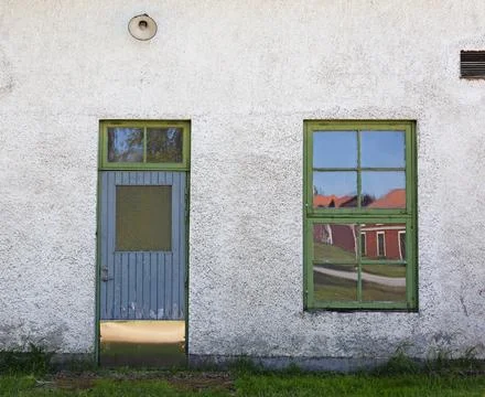 A door and a window to an old whitewashed house in Robertsfors Foto stock