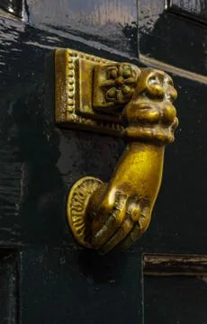 Door with brass knocker in the shape of a hand, beautiful entrance Stock Photos