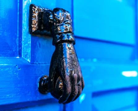 Door with brass knocker in the shape of a hand, beautiful entrance Stock Photos