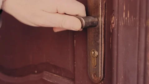 The door closes the man's hand inserts the key into the keyhole turns and locks 库存影片 195732217