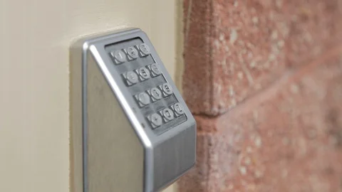 Door code lock outside tilt down toward door handle close Stock Footage 104310076