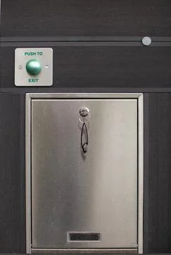 Door exit mechanism with push button and metallic finish in a modern setting Stock Photos