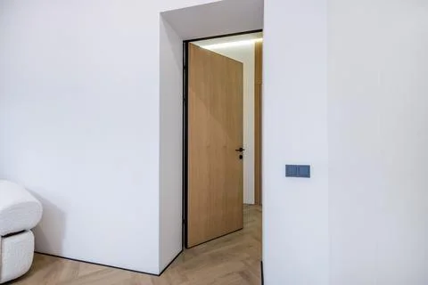 Door handle and light switch next to it in a bright room or office 스톡 사진