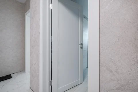 Door handle and light switch next to it in a bright room or office Stock Photos