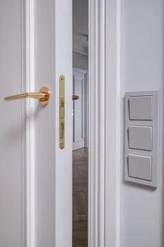 Door handle and light switch next to it in a bright room or office 스톡 사진