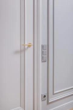 Door handle and light switch next to it in a bright room or office 스톡 사진