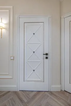 Door handle and light switch next to it in a bright room or office Stock Photos