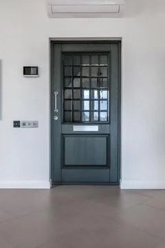 Door handle and light switch next to it in a bright room or office Stock Photos