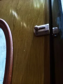 A door handle and lock embedded in the brown door Stock Photos