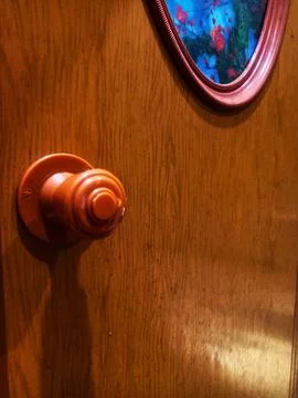 A door handle and lock embedded in the brown door Stock Photos