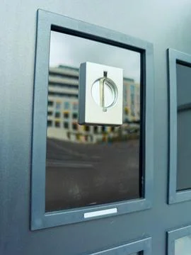 Door handle on a gray surface reflects buildings in the background during a.. Stock Photos