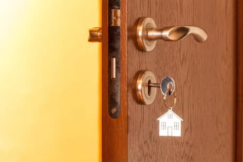 Door handle with inserted key in the keyhole and house icon on it Stock Photos