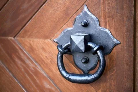 Door handle knocker selective focus on brown old wooden door with copyspace. Stock Photos