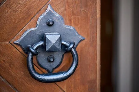 Door handle knocker selective focus on brown old wooden church entrance door Foto stock