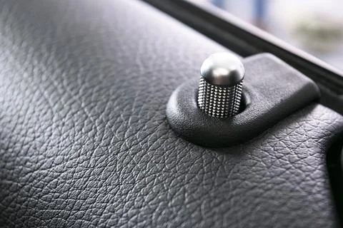 Door handle with lock control buttons of a luxury passenger car. Black leat.. Photos