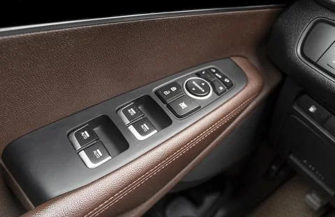 Door handle with power window control buttons of a luxury passenger car. Br.. Photos