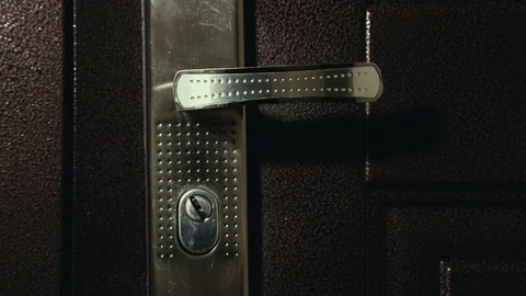 The door handle turns aggressively as if door is forcing by robber, close up Stock Footage 111754841