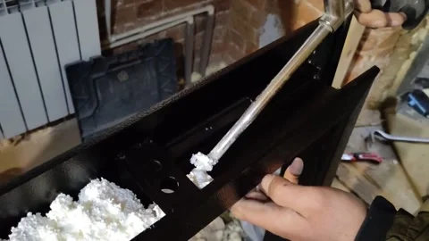 Door installation process. Polyurethane foam is squeezed onto a metal part Stock Footage 145731393