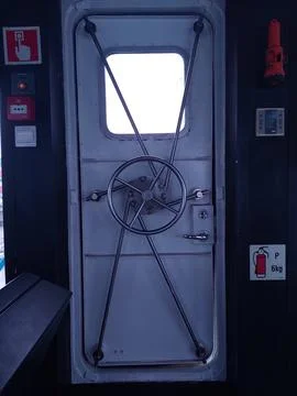 A door with its system located on the bridge of the tugboat Stock Photos