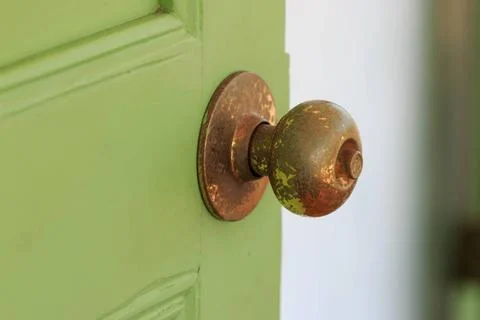 Door knobs Door knobs made of brass with green old wooden door. Copyright:... Fotos de archivo