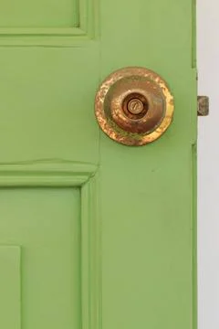 Door knobs Door knobs made of brass with green old wooden door. Copyright:... Fotos de archivo