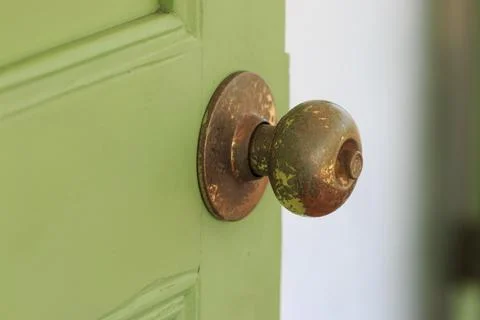 Door knobs made of brass with green old wooden door Fotos de archivo