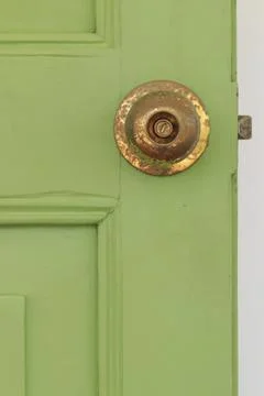 Door knobs made of brass with green old wooden door Fotos de archivo