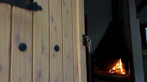 Door opened with keys in it and fire burning in fireplace Stock Footage 152397441