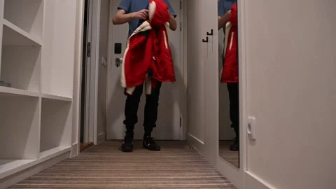 Door opens, lights come on man comes home hangs up jacket takes off shoes Stock Footage 307666394