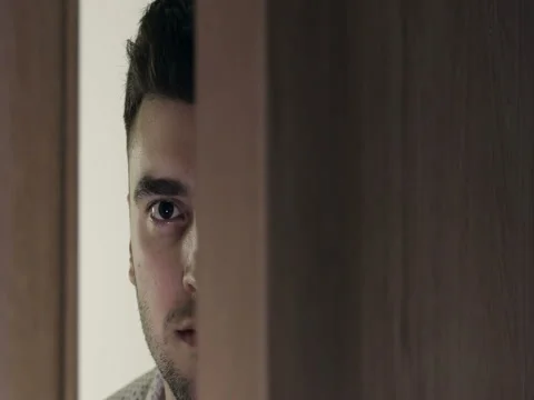 The door opens. Surprised face of a handsome young man. The door closes. Stock Footage 74831544