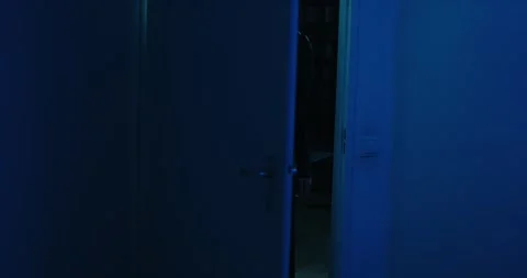 A door slowly opens and reveals the dark and scary silhouette of a ghastly Stock Footage 253398707