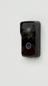 Doorbell camera mounted on white wall, providing home security and surveillan Stock Photos