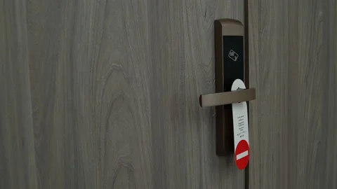 On the doors hangs a plate do not disturb. Woman goes and hangs a plate please Stock Footage 91521892
