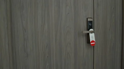 On doors hangs a plate do not disturb. Man goes from room, and hangs plate Stock Footage 91522146