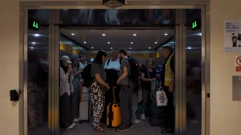 Doors open and close on a crowded elevator full of people with luggage Stock Footage 320243144