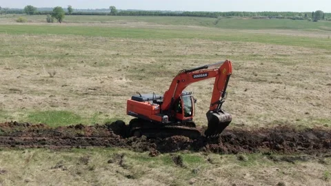 The DOOSAN excavator works in the field. Stock Footage 157223653