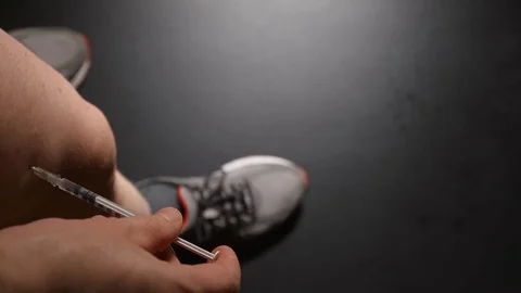 DOPING: Athlete takes an injection himself in a leg Stock Footage 71711516