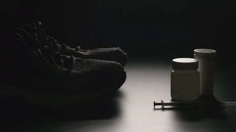 DOPING: Plastic containers, syringe and sport shoes - Dolly shot Video stock 71753380