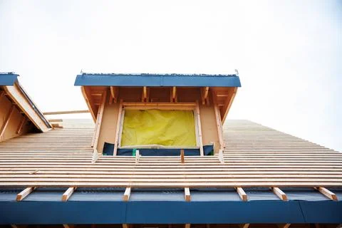 Dormer framing in progress with rafters, battens, and blue drip edge Stock Photos
